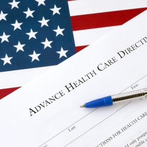 Advance health care directive blank form and blue pen on United States flag close up